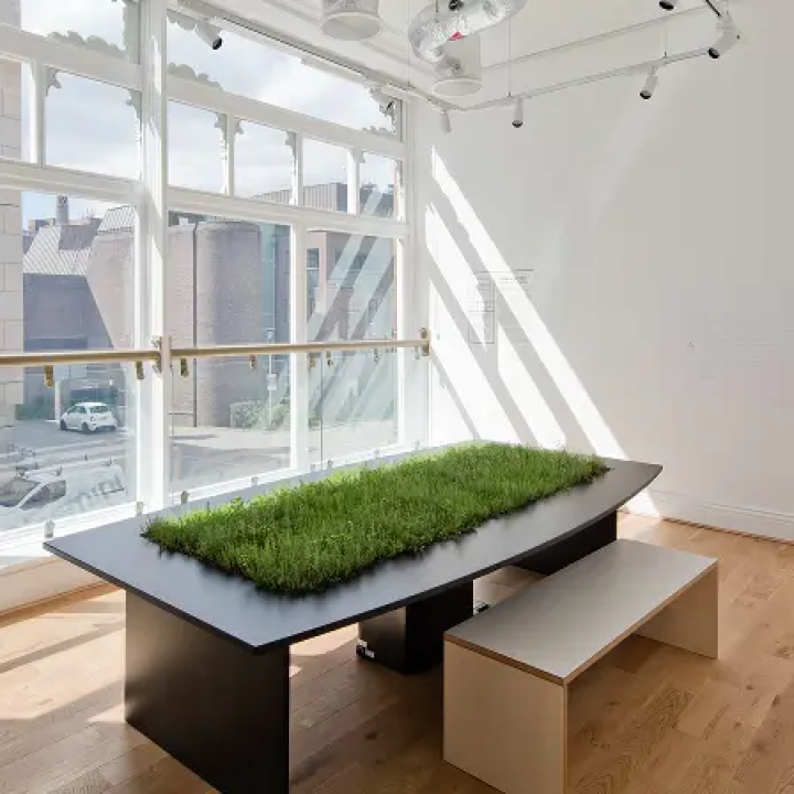 A black table with artificial grass on it