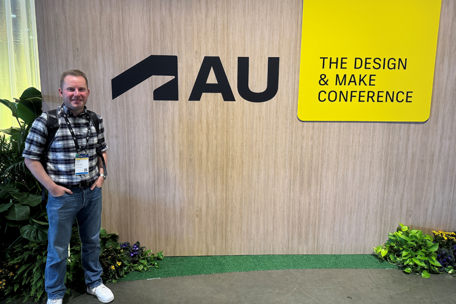 Nick Craggs, Associate Director of SPACE Architects, stands in front of the AU sign