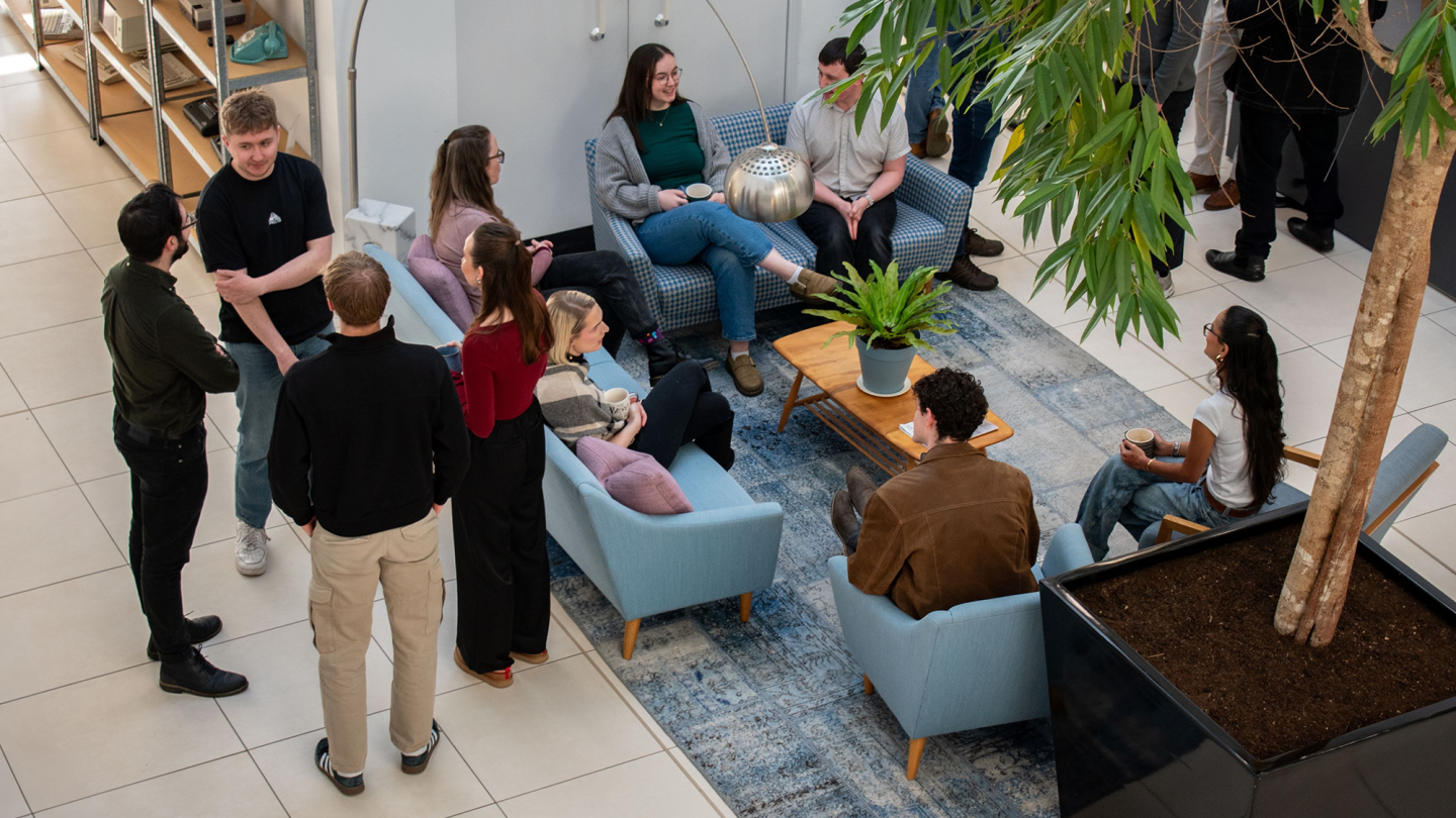 A birdseye image of SPACE Architects members sitting and standing while drinking coffee
