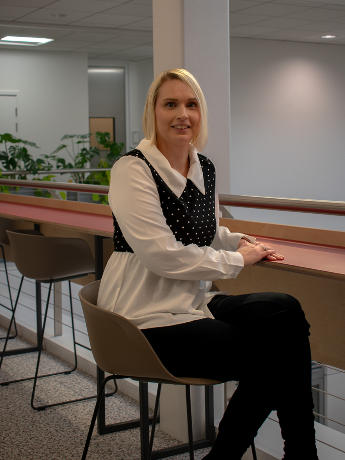Donna Khan sits on a stool perched over a balcony