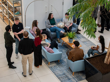 A birdseye image of SPACE Architects members sitting and standing while drinking coffee