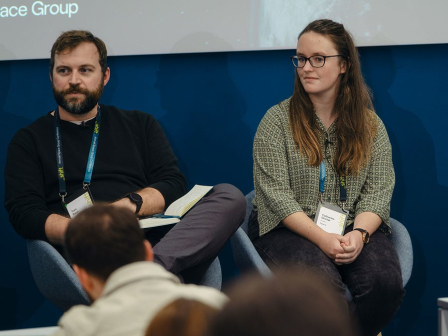Catherine Sinclair RIBA Journal Rising Star joins the panel at _shift climate conference, she wears a patterned green shirt and glasses