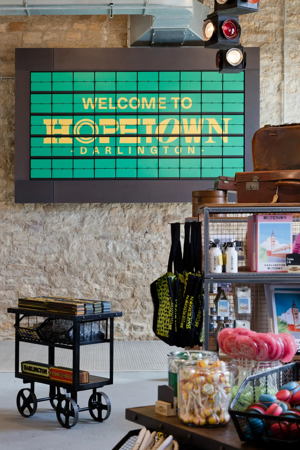 A portrait image from the Hopetown Darlington gift shop, with a green welcome sign