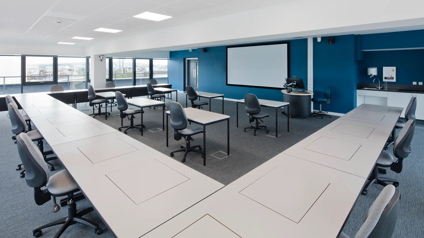 Collaborative seminar room with screen and blue walls