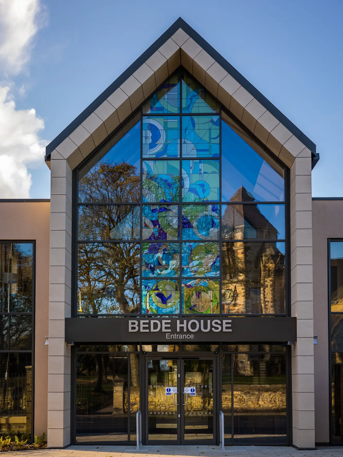 Outside the Bede House care home entrance, with large geometric shapes in window