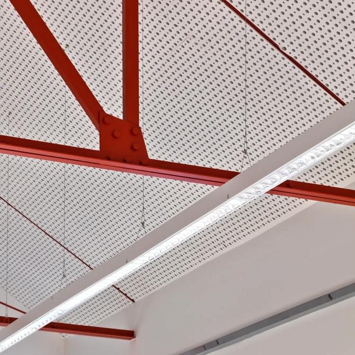 Ceiling details with perforated panels and red metal beams