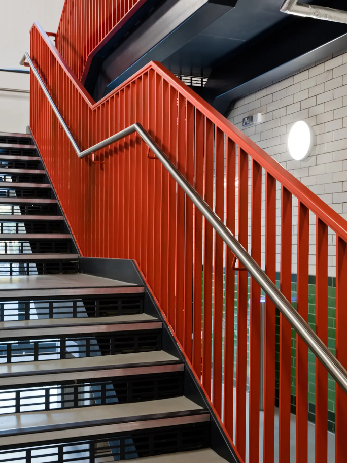 A close-up portrait image of the red metal banister on the main stairwell