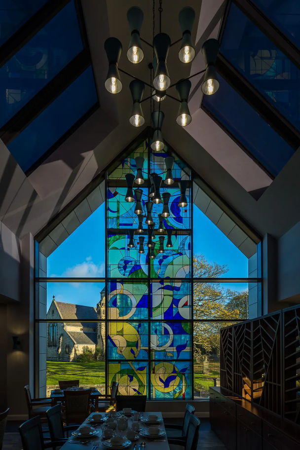 An inside view of the Bede House stained glass window with geometric patterns