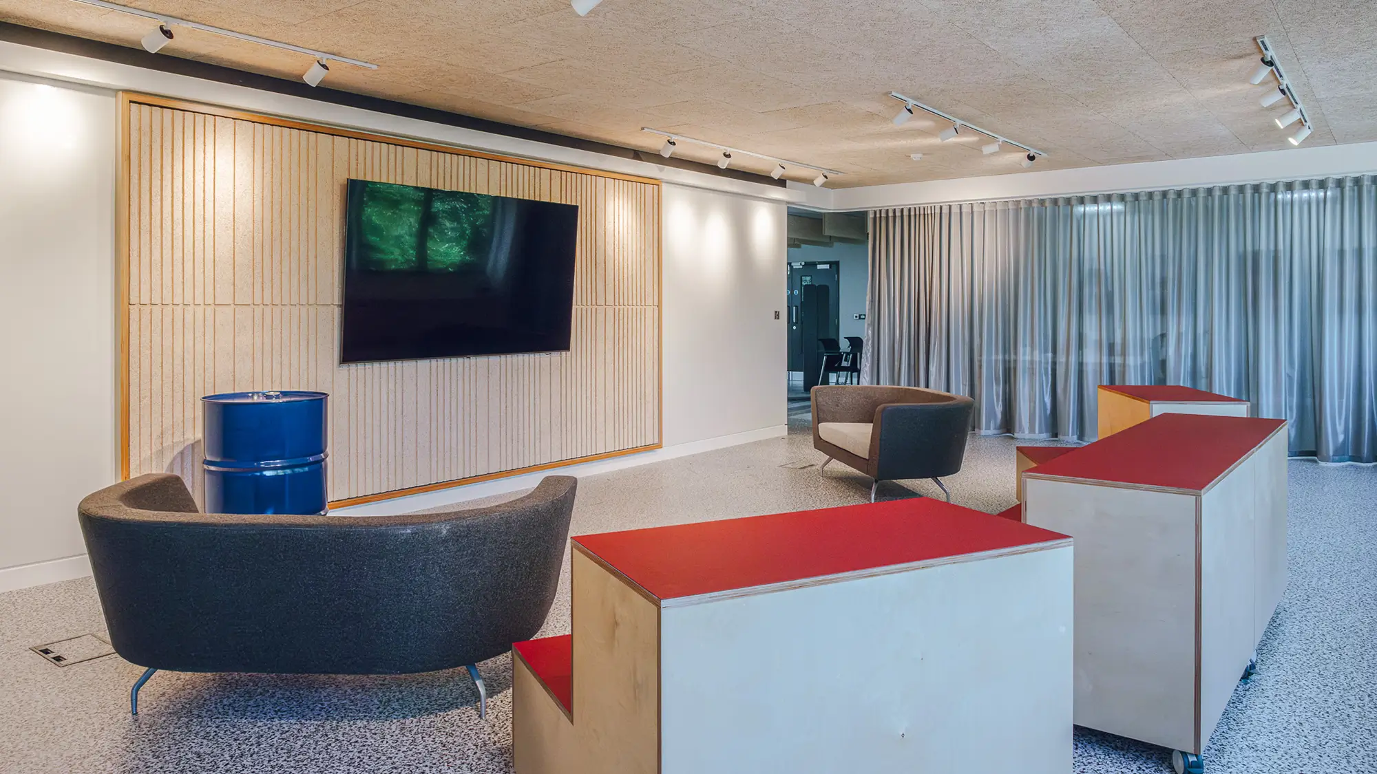 The 'dancefloor' meeting space, where monthly Pizza Friday meetings occur, fit with two large sofas and wooden seating areas