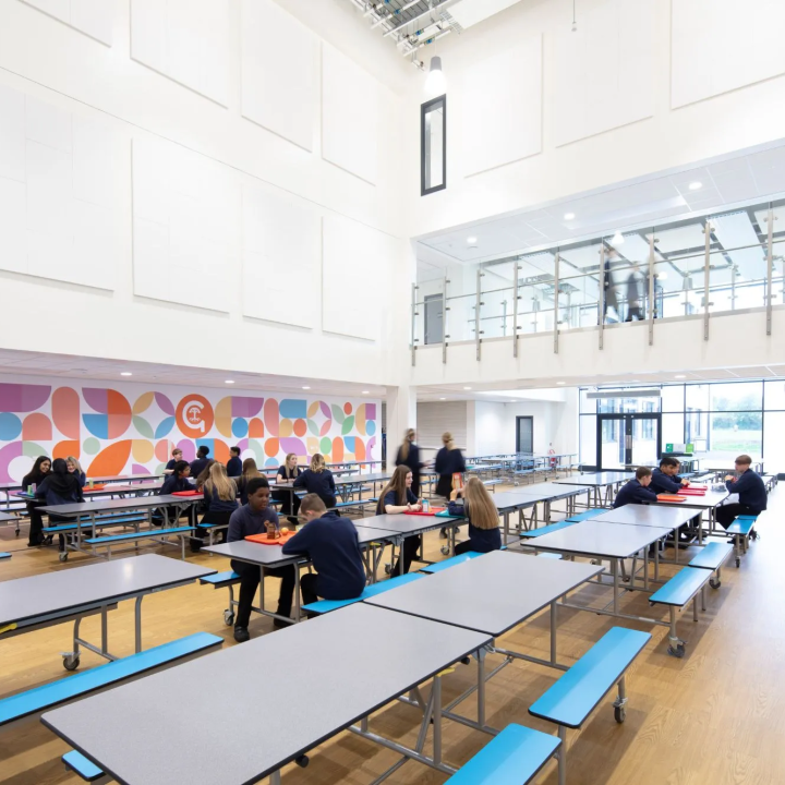 Students walking down some stairs, there is an inspirational quote on the wall in front of them