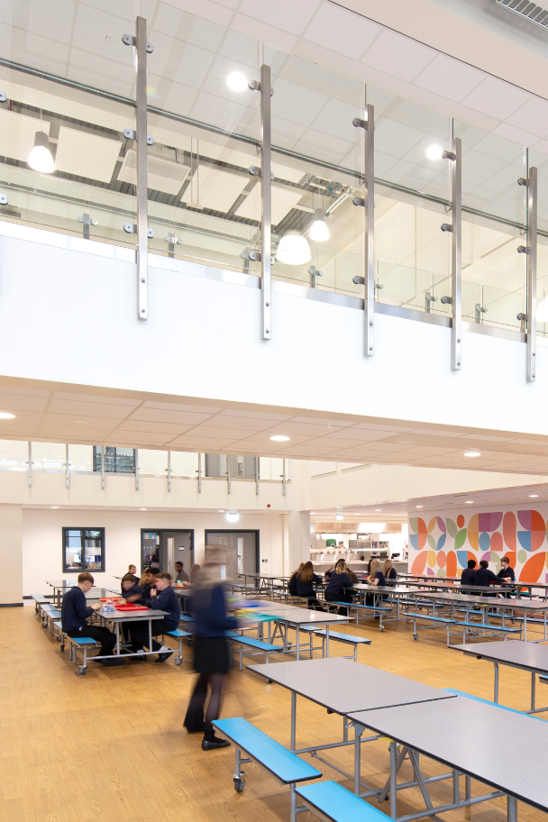 Long-shot of Callerton Academy, showing off the profile of the academy with children walking along the path