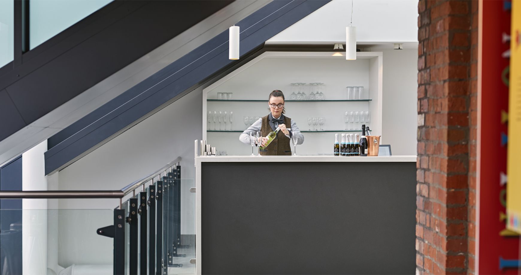 Bartender opening a bottle of white wine behind the refurbished bar at Darlington Hippodrome